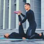 athletic-fitness-couple-is-exercising-aerobic-mat-modern-building-background_613910-9091